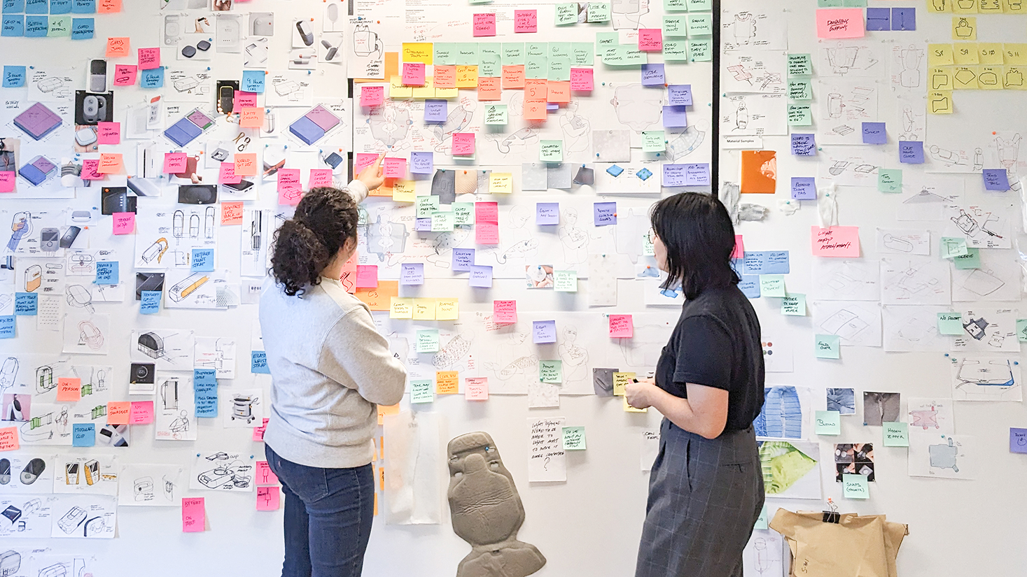 two designers looking at their concept board