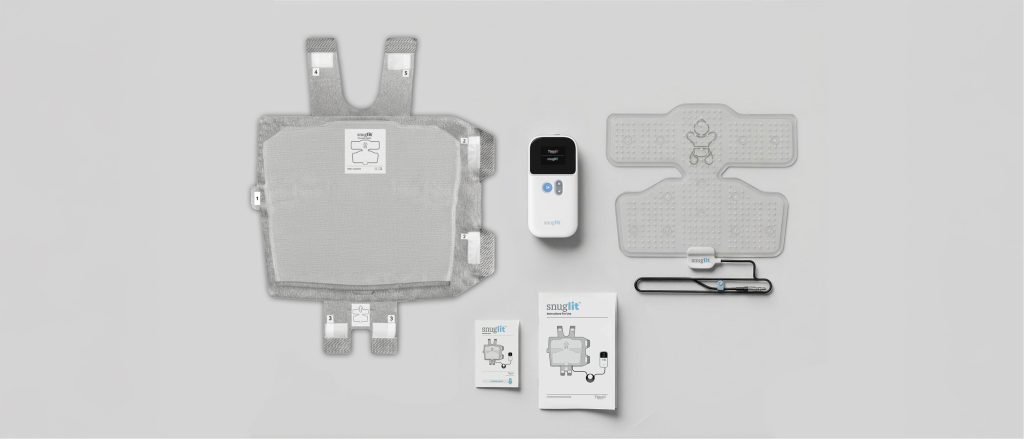 A display of Snuglit phototherapy items including the wearable phototherapy device, the fabric wrap, the controller, the instruction pamphlet